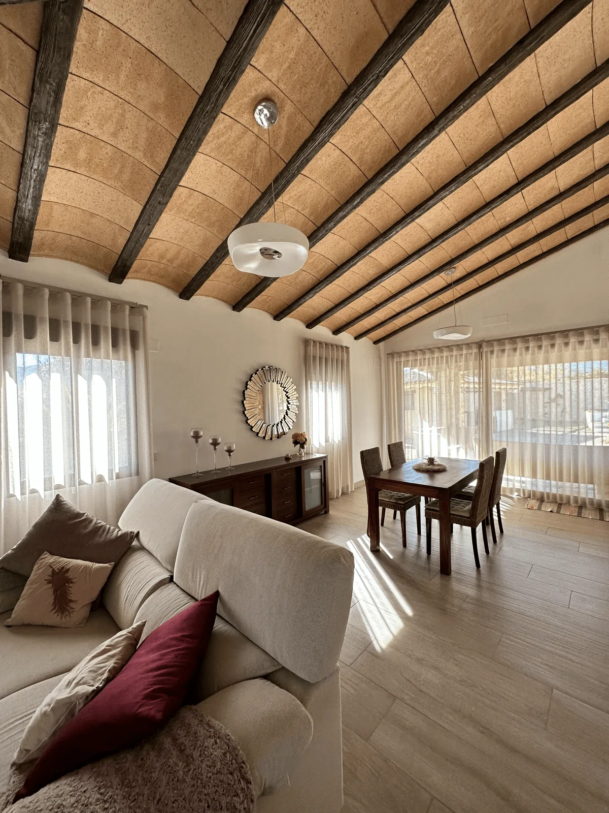 Salón con visillo a medida y techo abovedado de madera