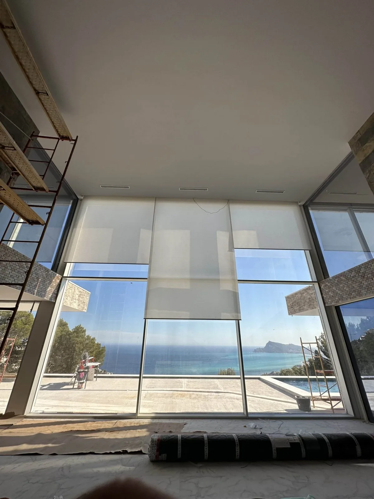 Instalación de estor motorizado en un ventanal panorámico de suelo a techo con vistas al mar Mediterráneo y el Peñón