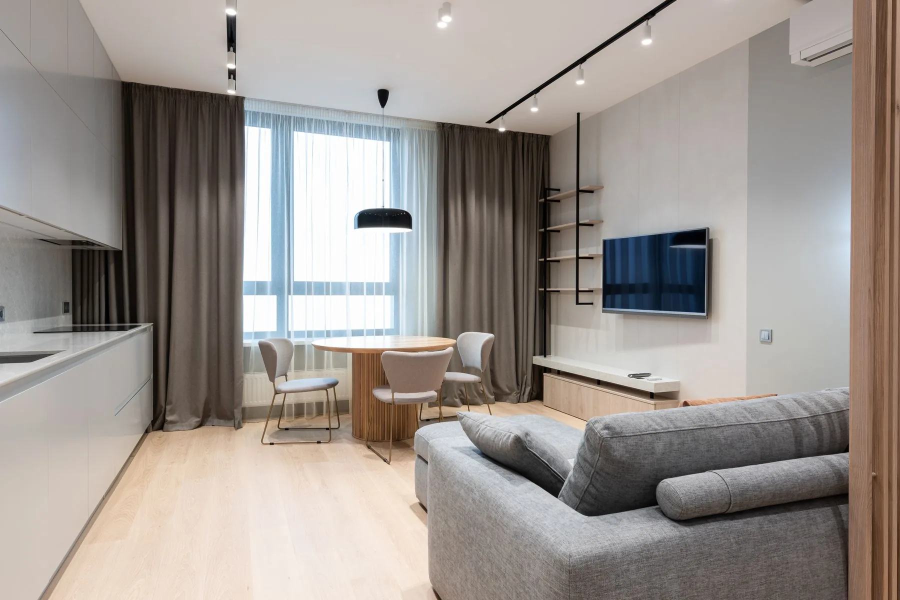 Salón de un apartamento con sofá y cortina junto a la ventana