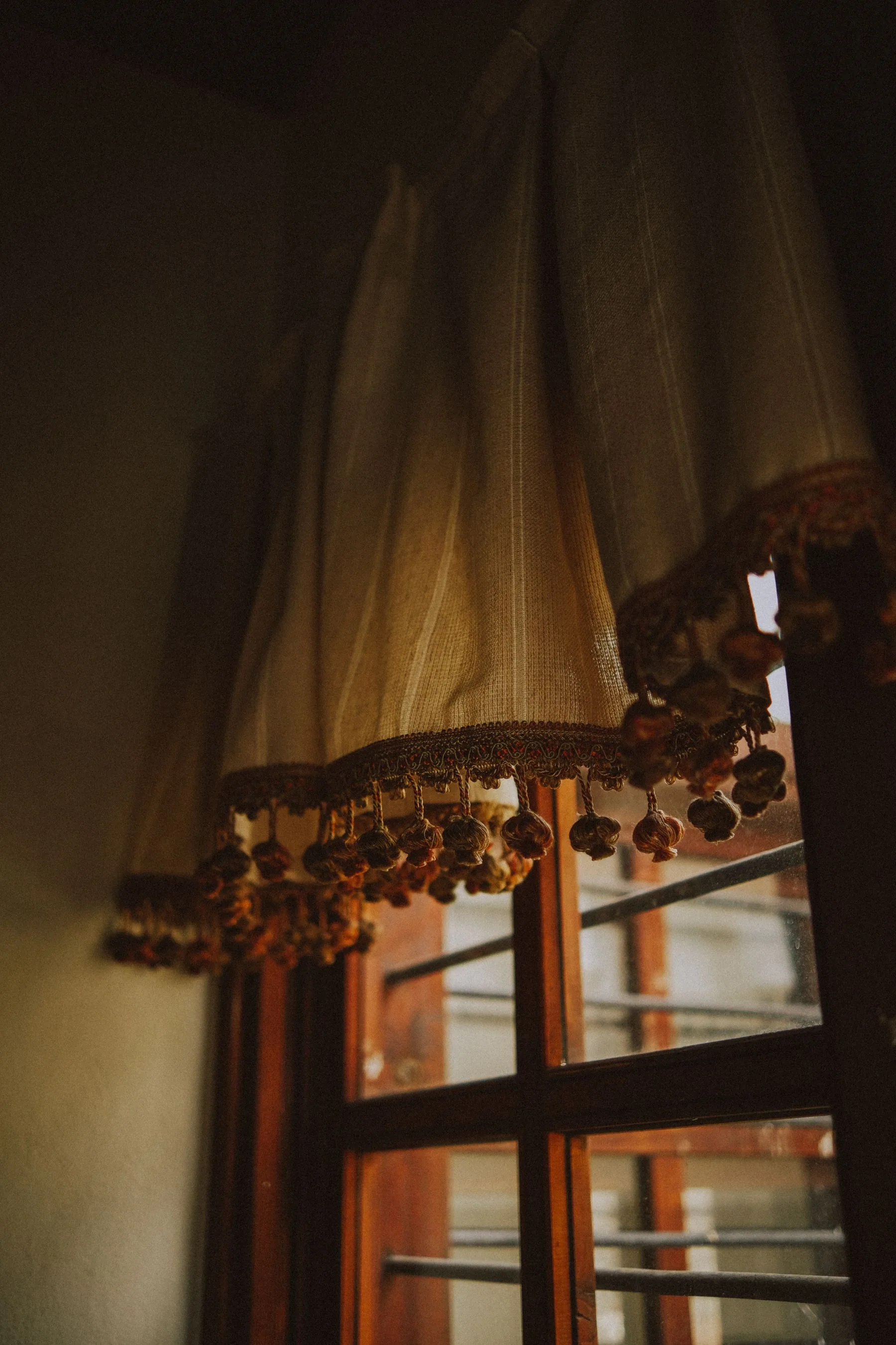 Detalle de una cortina con acabado decorativo junto a la ventana