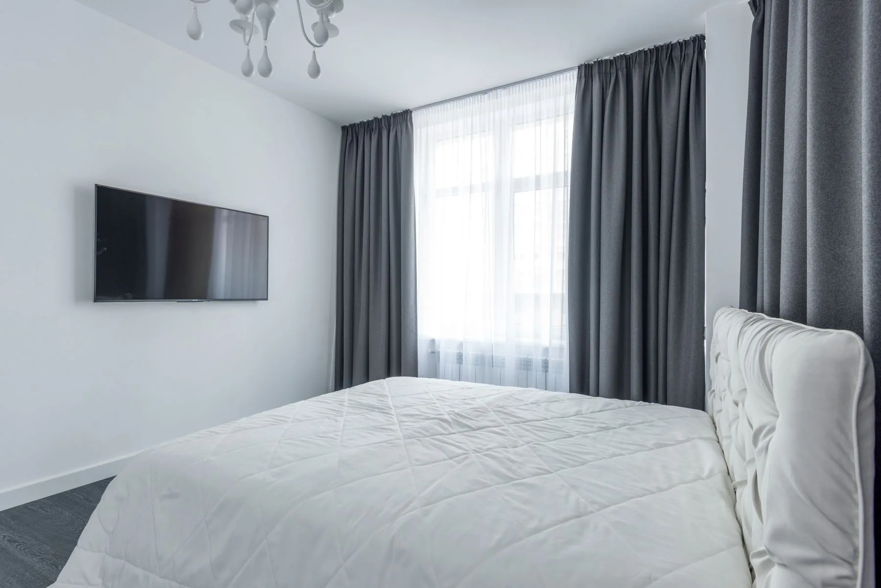 Dormitorio moderno con cortinas junto a la cama