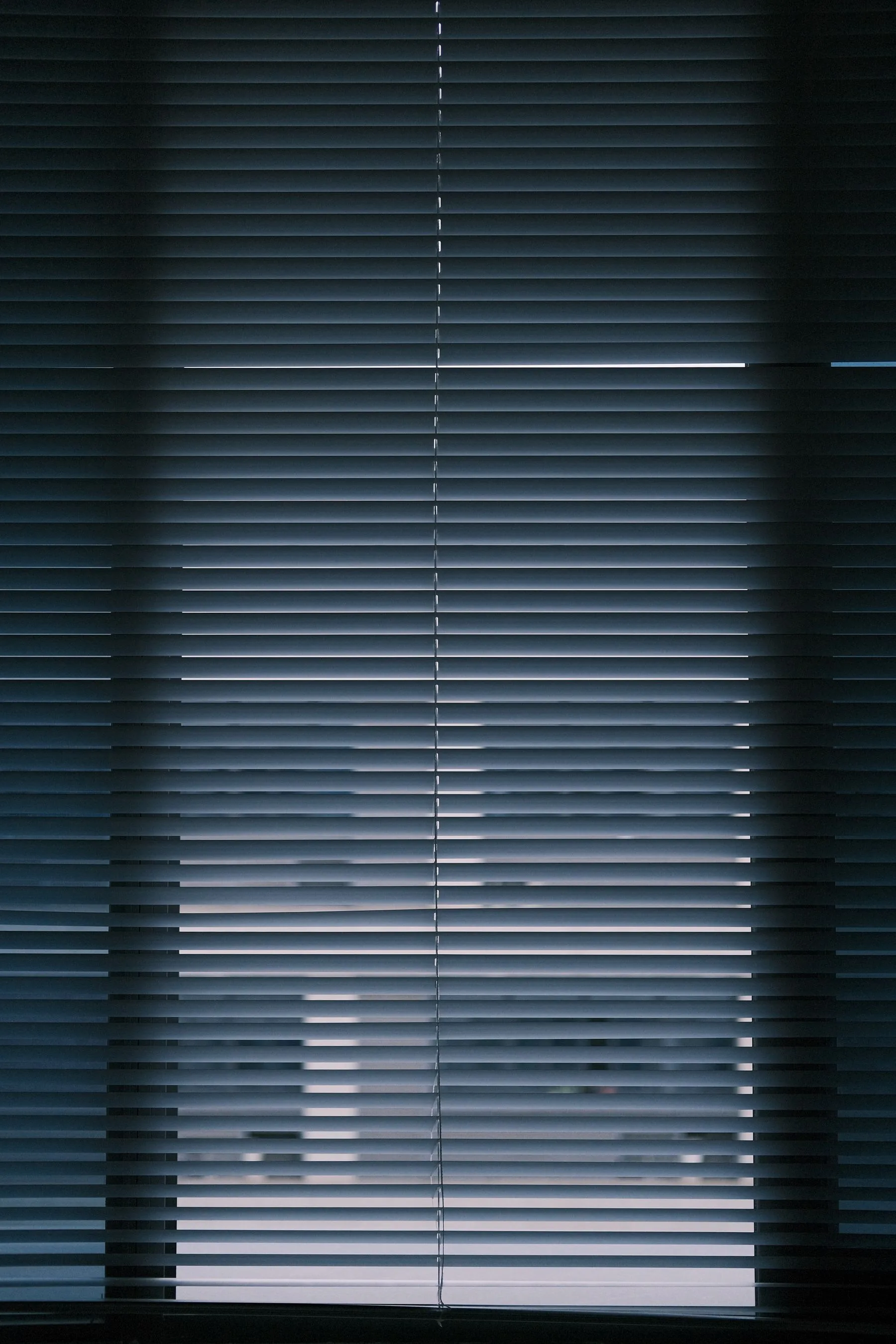 Estor cerrado creando un ambiente oscuro en la habitación