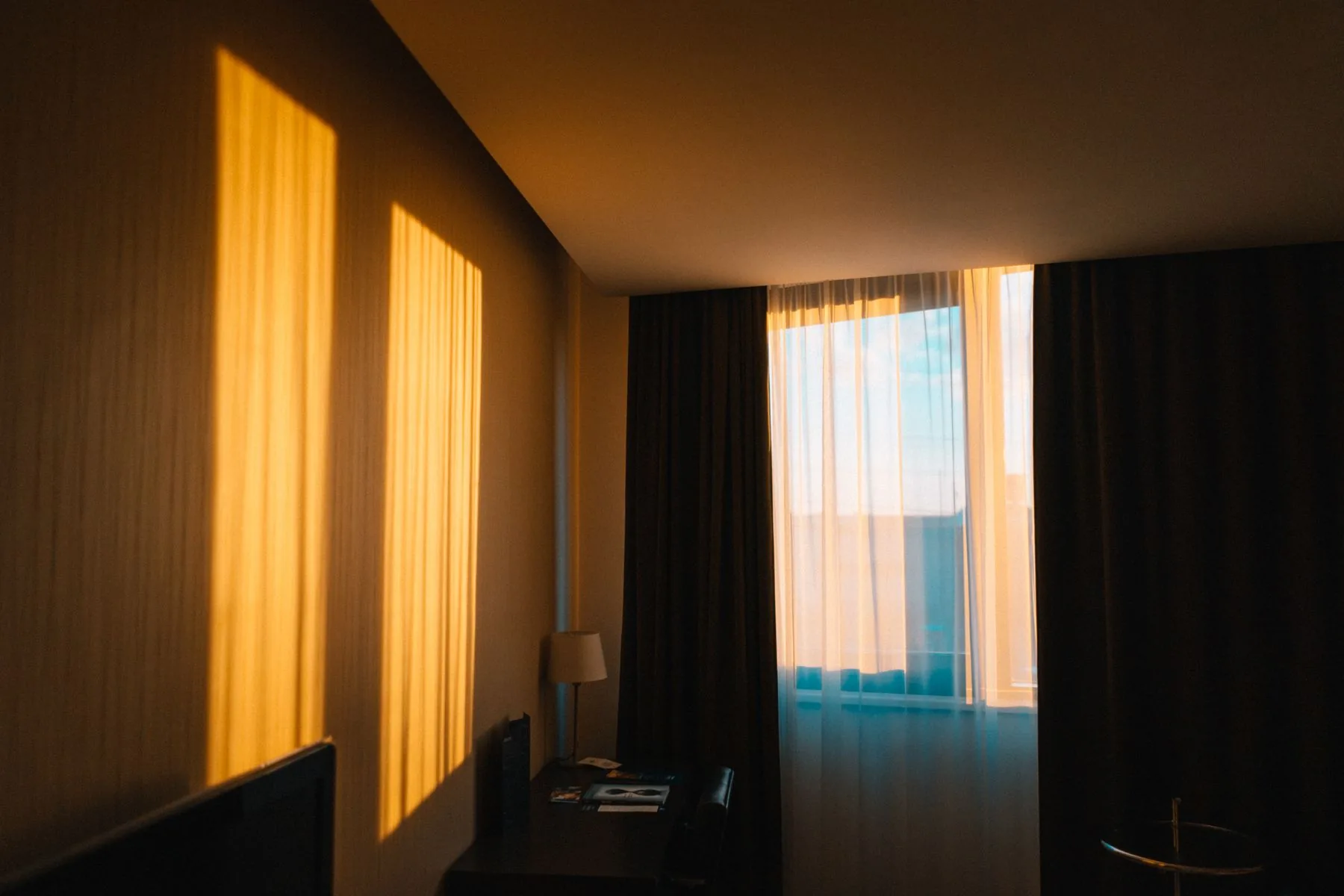 Habitación de hotel luminosa con cortinas junto a la ventana
