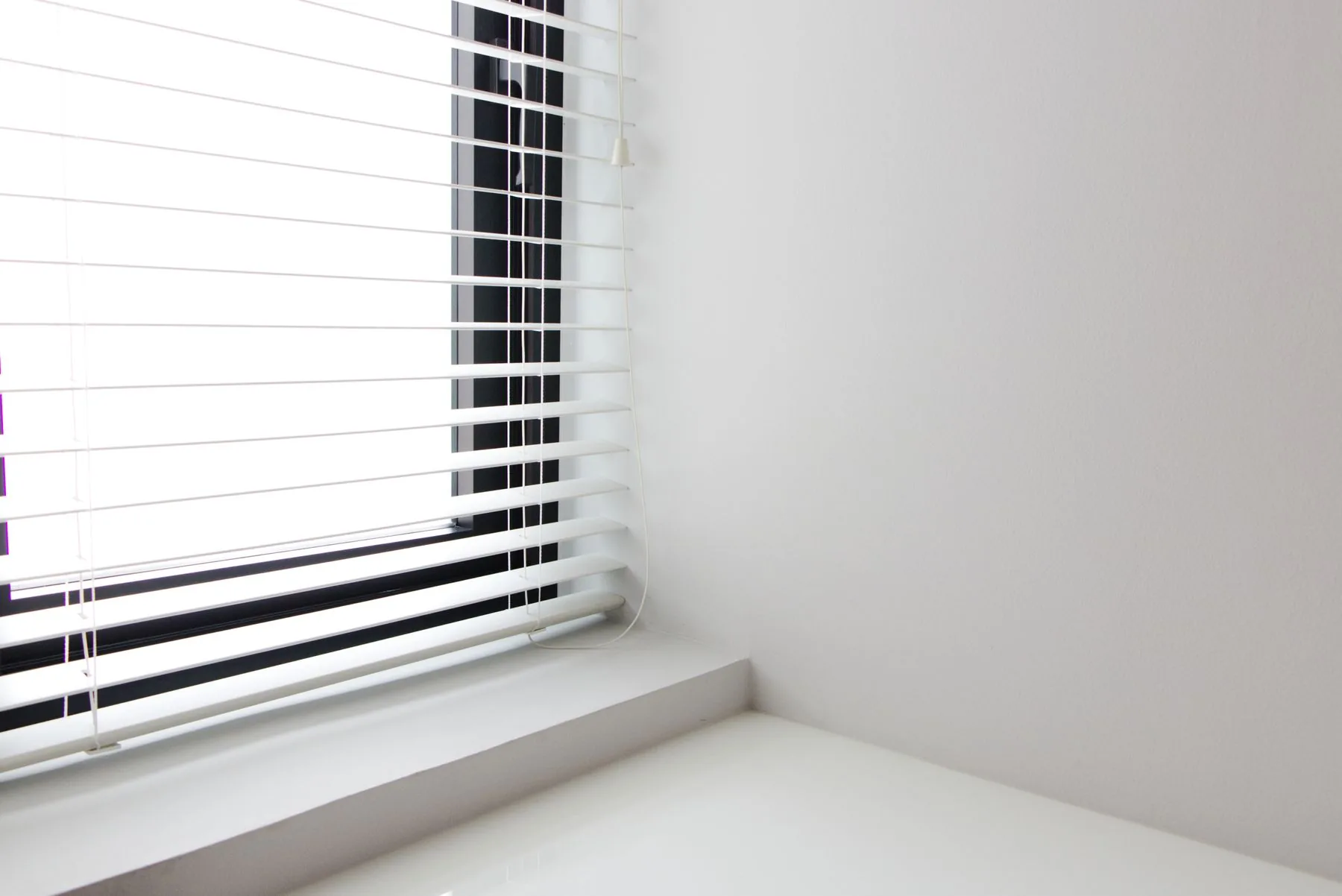 Interior minimalista con estor blanco en la ventana