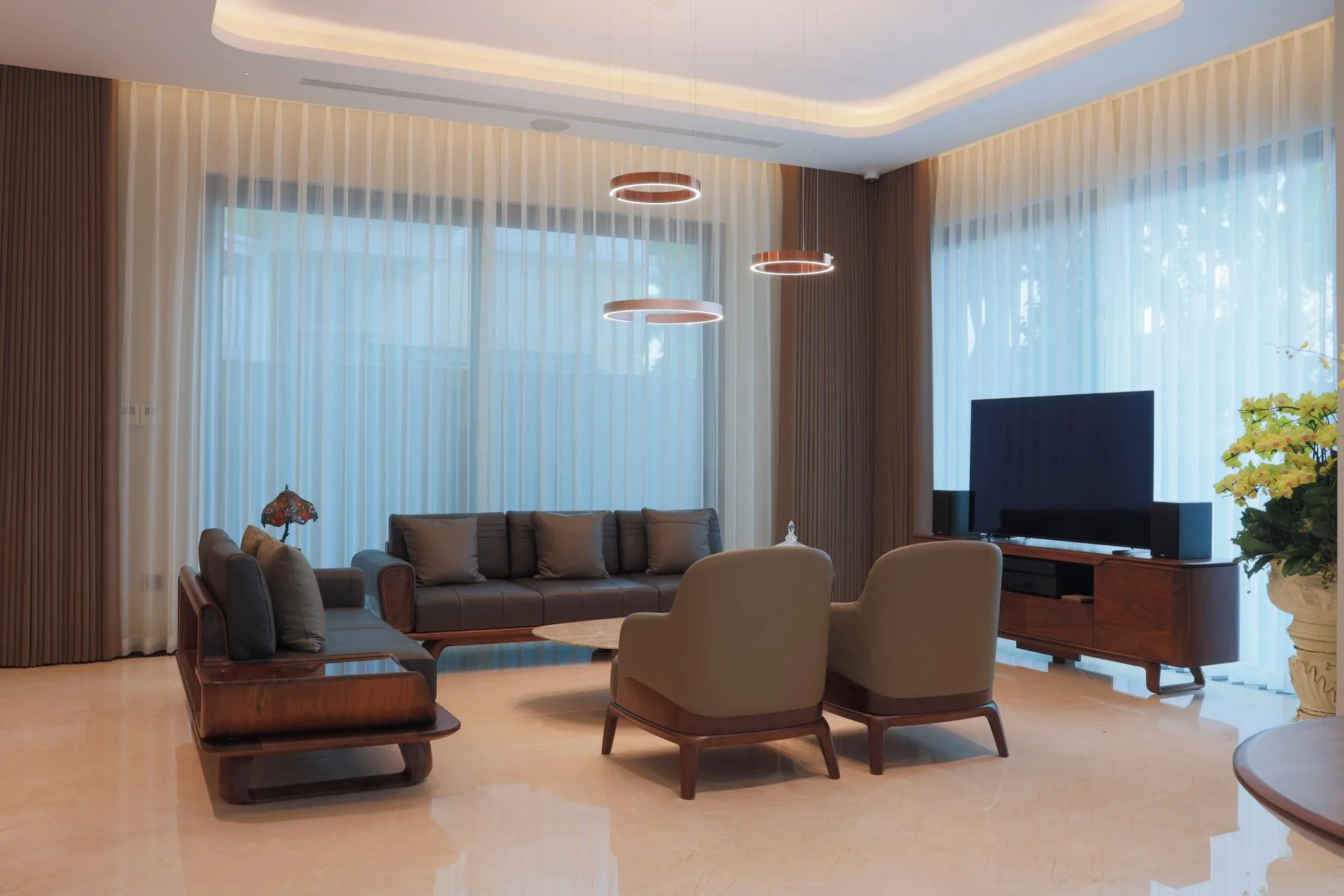 Salón contemporáneo con cortinas y mobiliario luminoso
