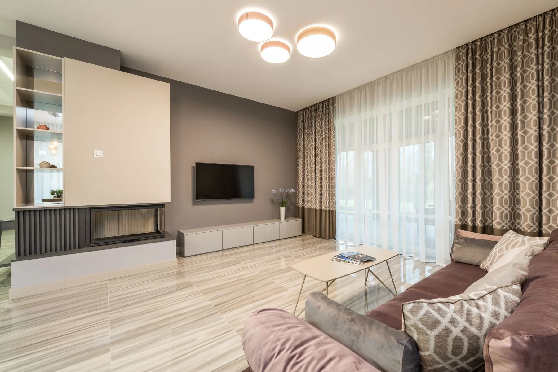 Salón luminoso con lámparas y cortinas junto al ventanal