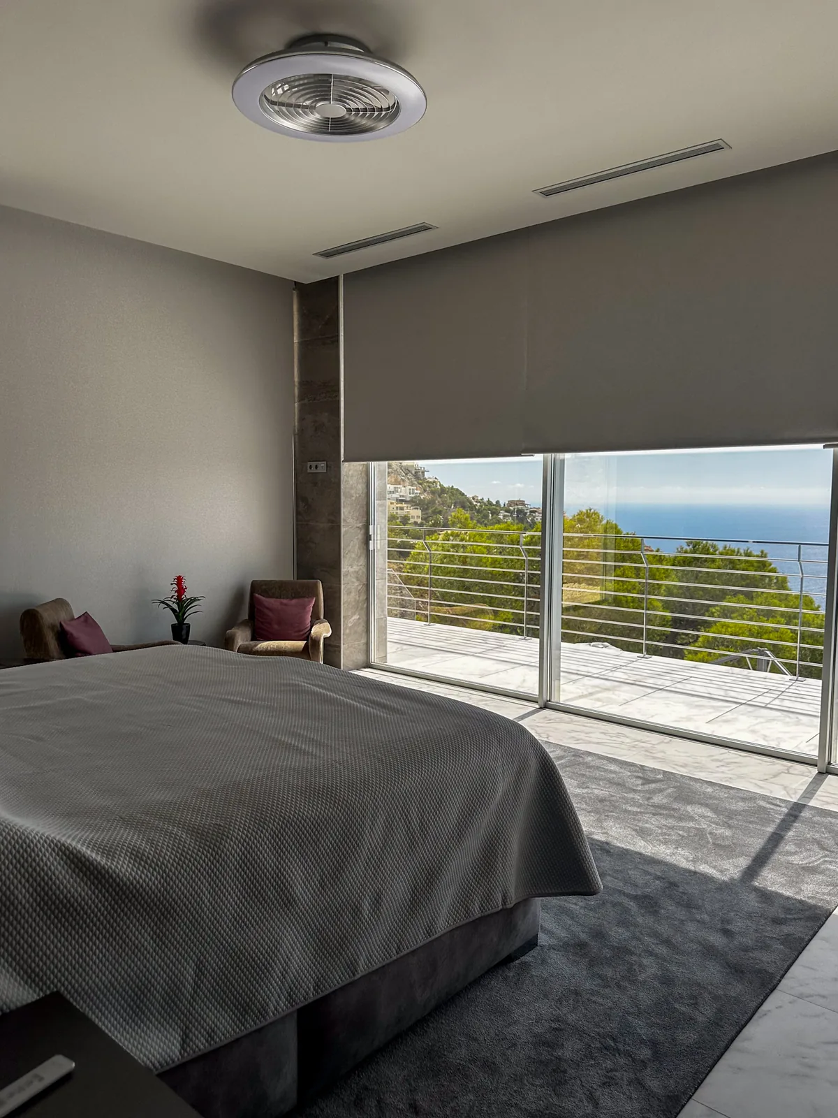 Roller blind in a bedroom with a large window and sea views